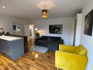 een woonkamer met een bank en een gele stoel bij De Parys Penthouse 5 in Bedford in Bedford