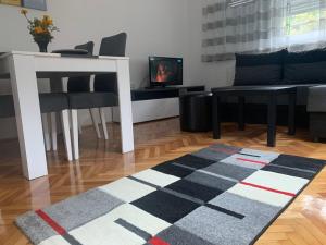 a living room with a table and chairs and a rug at Lana in Arandelovac