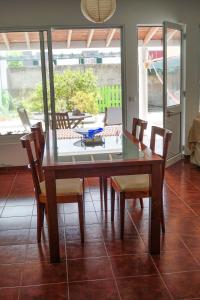 comedor con mesa de cristal y sillas en Casa das Hortênsias, en Ponta Delgada