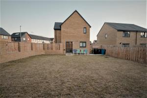 a yard with two houses and a fence at Willow Heights Modern 5-7 Persons/3 Bed Detached in Rotherham