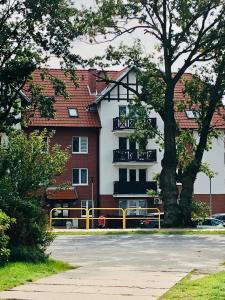 a building with a yellow fence in front of it at Apartament Alicja in Sztutowo