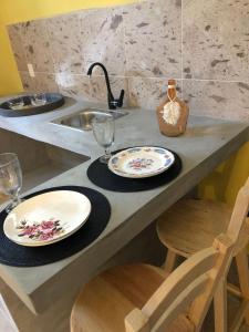 a kitchen counter with two plates and glasses and a sink at Casa Monarca in Oaxaca City