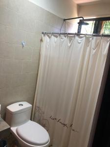 a bathroom with a toilet and a shower curtain at Casa Monarca in Oaxaca City
