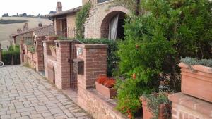a brick wall with potted plants on the side of a house at Appartamento con vista panoramica in Pienza