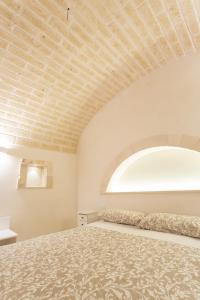 um quarto com uma cama grande com teto em Trullo dei maestri em Locorotondo