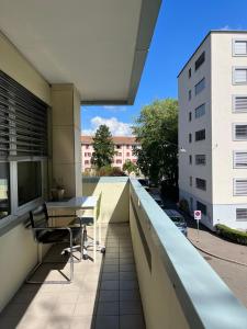 - un balcon avec une table et des chaises dans un bâtiment dans l'établissement Feel at home - central & cosy, à Bâle