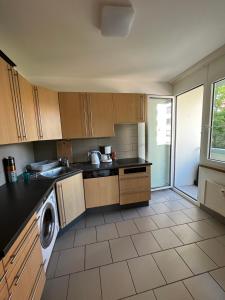 a kitchen with wooden cabinets and a washer and dryer at Feel at home - central & cosy in Basel