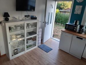 Rosmarinchen في Waabs: مطبخ مع خزانة بيضاء مليئة بالأطباق