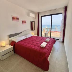 a bedroom with a red bed with a view of the ocean at F1 - Modern two bedrooms Flat sea View, St Julians in St Julian's