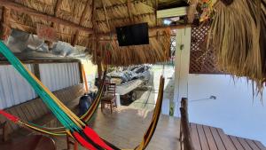 a room with a hammock and a tv in it at Hostal Blood Moon in Rio Dulce