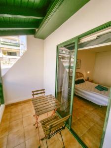a room with a bench and a bed in it at Arena Nest Hostel in Puerto de Santiago