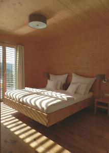 a bedroom with a large bed with white sheets and pillows at Das Grasberghaus in Grasberg