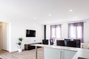 a white living room with a table and chairs at Villa mi Pequeña Alba in Barbate