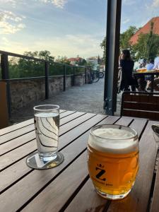 zwei Gläser Bier auf einem Holztisch in der Unterkunft DOMOV-VINA Holiday Apartment in Znojmo