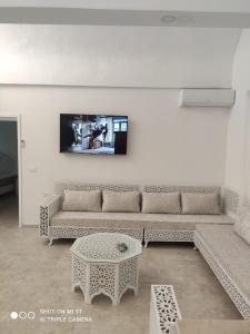 a living room with a couch and a table at Villa La Palmeraie d'Arkou, grande piscine in Arkou