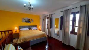 ein Schlafzimmer mit gelben Wänden und ein Bett mit zwei Lampen in der Unterkunft Cantinho Rural in Camacha