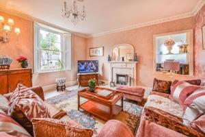 a living room with a couch and a fireplace at The Town House at Muntham- Luxury Holiday Home with Hot Tub in Torquay