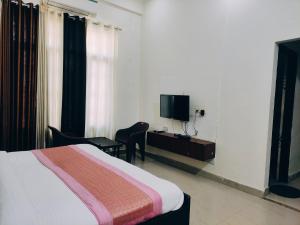 a hotel room with a bed and a tv at IIDM ECO RESORT in Lucknow