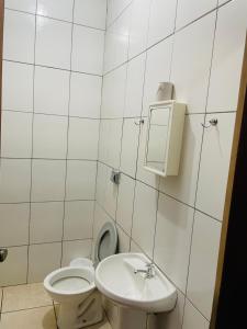 ein weißes Bad mit einem WC und einem Waschbecken in der Unterkunft Hotel Solaris in Três Lagoas