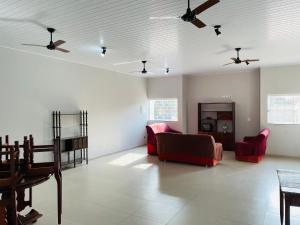 Hotel Solaris في تريس لاغواس: غرفة معيشة مع أريكة وكراسي ومراوح سقف