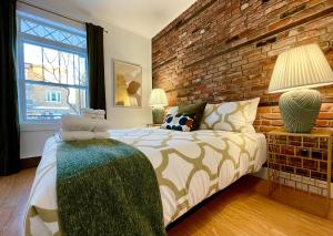 1 dormitorio con cama y pared de ladrillo en PMTEEL en Quebec
