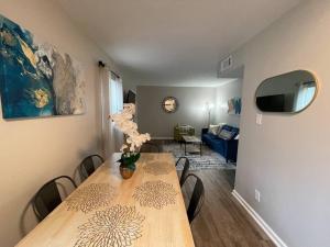 Una mesa de comedor con un jarrón de flores encima. en * Prime Place * Pet Friendly * King Bed *, en Durham