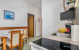 a kitchen and dining room with a sink and a table at Cozy Apartment In Brzac With Wifi in Brzac