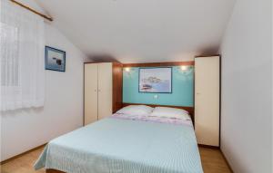 a small bedroom with a bed and a blue wall at Cozy Apartment In Brzac With Wifi in Brzac