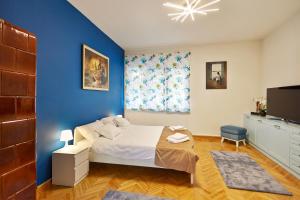 um quarto azul com uma cama e uma parede azul em Marina Apartment em Belgrado
