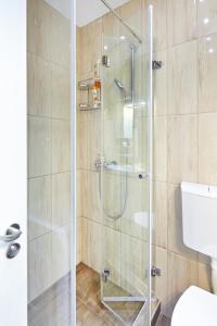 um chuveiro com uma porta de vidro na casa de banho em Marina Apartment em Belgrado