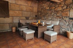 a patio with a table and chairs and a stone wall at Casa Vacacional en Vilagarcía de Arousa in Vilagarcia de Arousa +66 photos