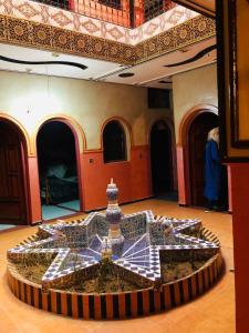 a room with a fountain in the middle of a floor at Hotel Restaurant Hollywood Africa in Aït Ben Haddou