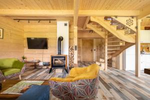 ein Wohnzimmer mit einer Holztreppe und einem TV in der Unterkunft Willa Tritri in Witów