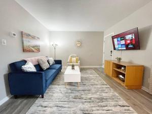 Una sala de estar con un sofá azul y un televisor. en * Cozy Crib * Pet Friendly * King Bed *, en Durham