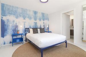 a bedroom with a bed and a blue and white wall at Roami at 250 Collins in Miami Beach