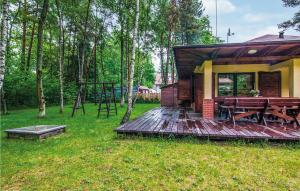 uma pequena cabina com um deque de madeira e uma mesa de piquenique em Cozy Home In Pobierowo With Wifi em Pobierowo