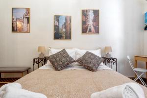 1 dormitorio con 1 cama con 4 cuadros en la pared en JoMi House of Art, Old Corfu Town, en Corfú