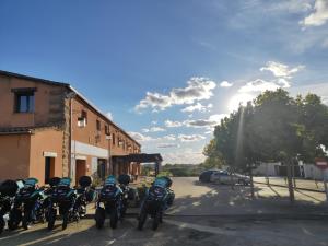 a group of motorcycles parked in a parking lot at El Huésped del Sevillano AR in Lagartera