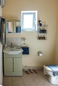 a bathroom with a sink and a toilet and a window at Elafonisi Vacation Blue Apartment in Agios Padeleimon