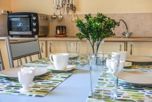 a table with plates and cups on top of it at Elafonisi Vacation Blue Apartment in Agios Padeleimon +26 photos