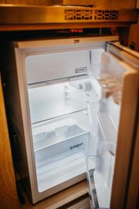 an empty refrigerator with its door open in a kitchen at City Penzion in Košice