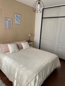 1 dormitorio con cama blanca y puerta blanca en Alquilo departamento por dia. Zona castelar!!! en Castelar