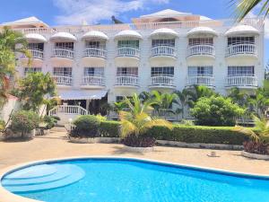 un hotel con piscina frente a un edificio en Piergiorgio Palace Hotel en Sosúa