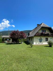 una casa con un césped verde delante de ella en Ferienhaus Mörtl en Tröpolach