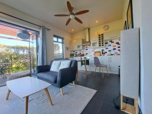 a living room with a chair and a kitchen at Domaine Coutelier in Stellenbosch