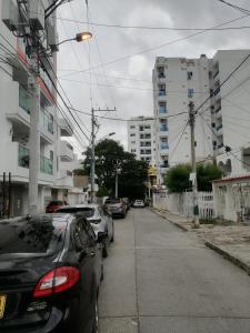 una fila di auto parcheggiate in una strada con edifici di Hermoso Apartaestudio, privado, acogedor, super aseado, excelente ubicación! a Cartagena de Indias
