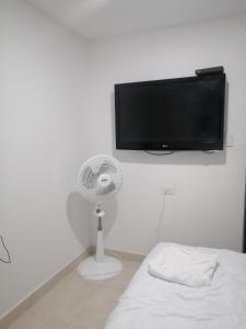 una camera da letto con ventilatore e TV a schermo piatto di Hermoso Apartaestudio, privado, acogedor, super aseado, excelente ubicación! a Cartagena de Indias