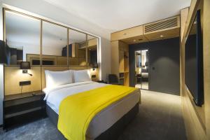 um quarto com uma cama grande e um cobertor amarelo em Trip Park Hotel em Istambul