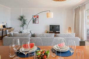 a living room with a table with wine glasses and a bowl of fruit at Monumental Place by An Island Apart in Funchal