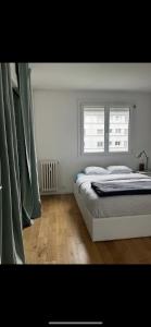 ein weißes Schlafzimmer mit einem Bett und einem Fenster in der Unterkunft Beau T3 60m2 très cosy proche du centre ville in Saint-Jacques